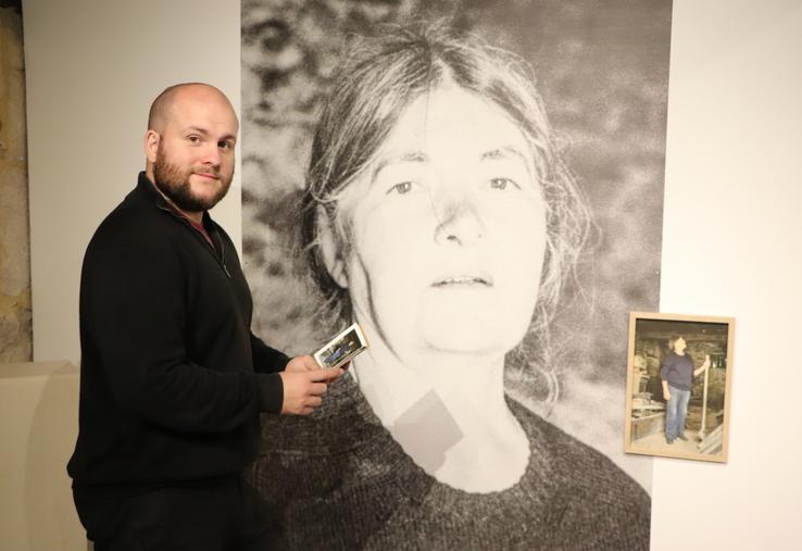 Charles Gelis, commissaire de l'exposition Cambrousse, devant le travail de Pierre-Yves Racine qui interroge "le retour chez soi, dans la grange, le bois de rénovation et la famille".